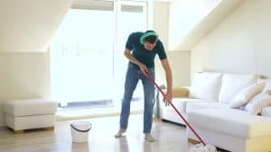 Man mopping floor with headphones on